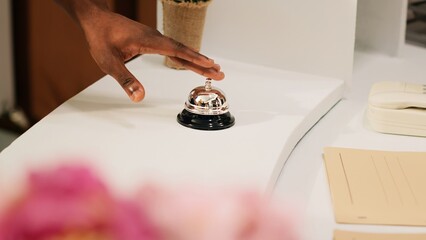 Hotel guests ringing service bell at front desk reception, calling for receptionist of tropical...