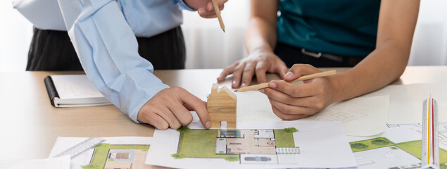 Professional architect team plans to build eco house at meeting table with green design document...