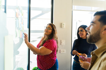 Plus size business woman having fun while using sticky notes in a team building activity