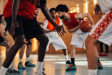 A hispanic basketball player defending ball during training with team. - obrazy, fototapety, plakaty