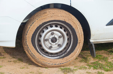 Car wheel completely covered in mud