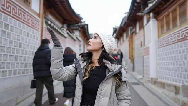 Slow-motion video of a young Filipino woman in her 20s taking a walk in Hanok Village, North Village, Seoul, Republic of Korea on a cold winter day 寒い冬の日に大韓民国ソウル北村韓屋村を散歩する20代の若いフィリピン人女性のスローモーションビデオ