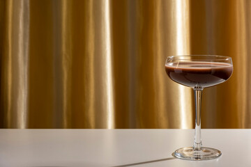 Espresso or chocolate martini cocktail on golden background