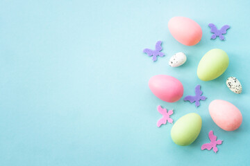 Easter background with Eggs, rabbit and spring flowers at blue background.