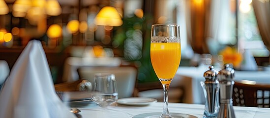 A glass of orange juice is placed neatly on a stylish restaurant table, exuding a refreshing and inviting vibe.