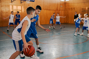 Young athletic boys practicing game at indoor court on training.