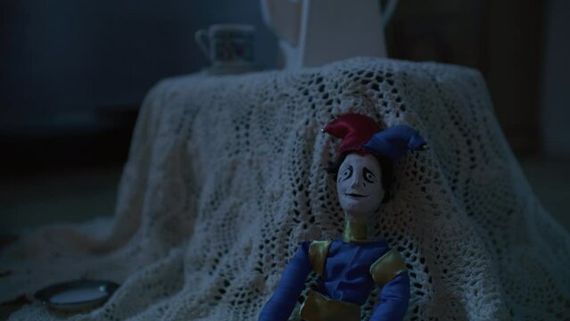 Toy clown sitting in an empty dark room.