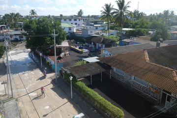 Fototapeta premium Partial view of the town of Puerto Villamil with some pedestrian walking and passing by, in the Galapagos Islands.