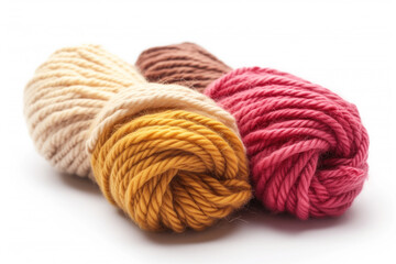 Close-up image of three colorful wool yarn skeins in beige, mustard, and maroon, isolated on a white background.