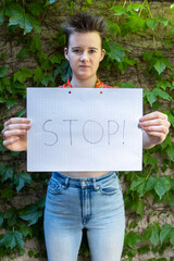 Stand Up: Young Woman Holds Stop Sign in Defense of Women's Rights. Vertical.