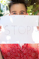 Gender Equality: Young Female Holds Stop Sign to Defend Women's Rights. Violence concept. Vertical.