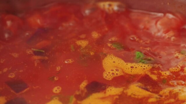 Beetroot soup, Cooking traditional national Russian, Ukranian soup Borsch close-up. Boiling red soup with vegetables and turkey meat and spices. Special red for Borsh from beet, tomatoes pasta