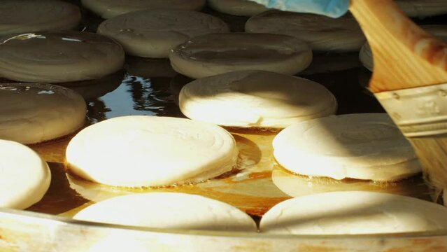 Cooking raditional chinese steamed buns Mantou in oil close-up. Mantou or bao bun with rice, green,spicies and meat. Local streetfood market outdoor