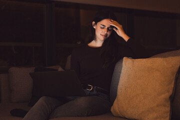 Obraz premium Stressed woman at late night having strong terrible headache attack after computer laptop study, sleepy exhausted girl suffering from chronic migraine massaging temples to relieve head ache tension.