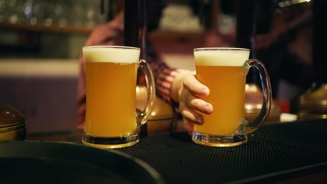 Beer pouring action: Bartender fills a glass with bubbles in a close-up view