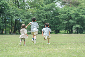 公園で追いかけっこする活発な子供達・兄弟・走る・短距離走
