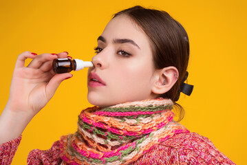 The nasal spray. Female in scarf using nasal spray medicine for runny nose. Nasal spray for...