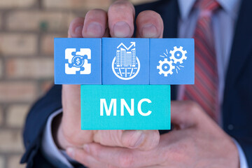 Businessman holding styrofoam blocks sees abbreviation: MNC. MNC Multinational Corporation business...