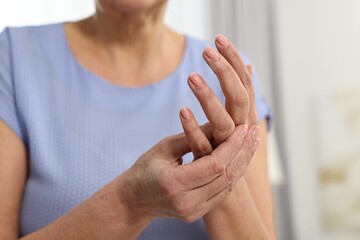 Arthritis symptoms. Woman suffering from pain in hand at home, closeup