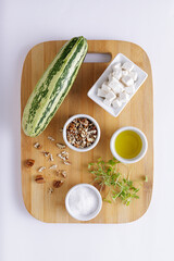 Cucumber Salad with White Cheese and Nuts Ingredients on a wooden chopping board and white background