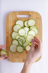 Cucumber sliced on a wooden chopping board and white background ingredient for recipe