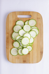 Cucumber sliced on a wooden chopping board and white background ingredient for recipe