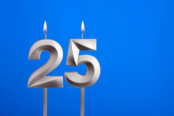 Birthday number 25 - Candle lit on blue background