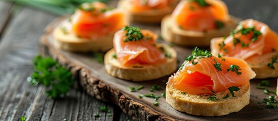 A gluten-free canape featuring homemade smoked salmon and parsley arranged on a rustic wooden tray, served with crackers.