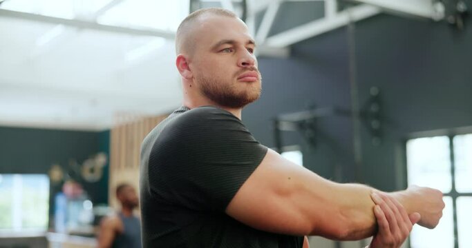 Fitness, club and man stretching arms for healthy body, wellness or exercise at gym. Warm up, training and serious strong person with muscle to workout for flexibility, sports or physical activity