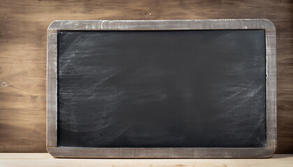 Empty blank black chalkboard with chalk traces; old wooden table surface background
