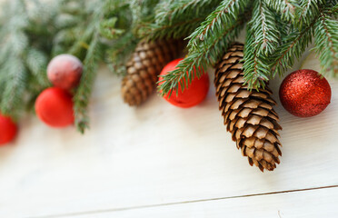 Christmas tree branches with cones, christmas decorations on white wooden texture ready for your design