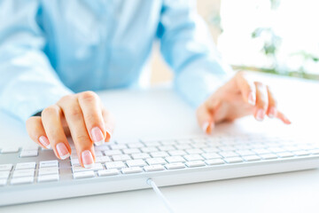 Woman office worker typing on the keyboard