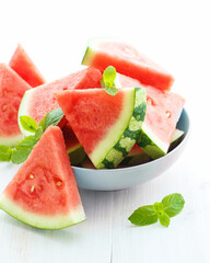 Triangular slices of fresh watermelon on white wooden background
