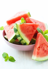 Triangular slices of fresh watermelon on white wooden background