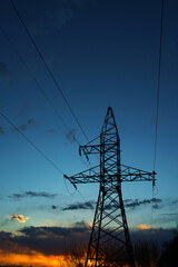 Power lines against the sky at sunset