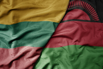 big waving national colorful flag of malawi and national flag of lithuania .