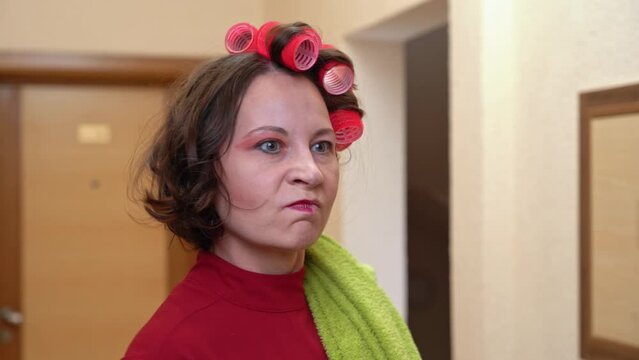 Dissatisfied woman, neighbor with bright makeup, wearing curlers, swears furiously, screams, demands silence, waves her finger annoying Landlord scolds for noise, emotionally expresses dissatisfaction