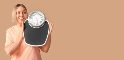 Woman holding scales on beige background with space for text. Weight loss concept
