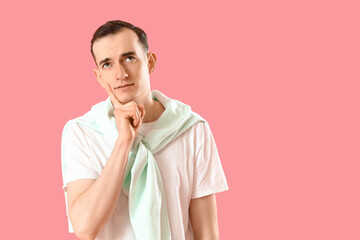 Thoughtful young man on pink background