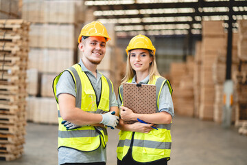 Engineer team standing walking in warehouse examining hardwood material for wood furniture production, Worker check stock, Technician man and woman working on quality control in lumber pallet factory