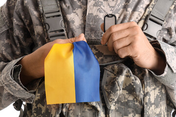 Male soldier with flag of Ukraine on white background