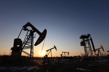 In the evening, oil pumps are running, Silhouette of beam pumping unit