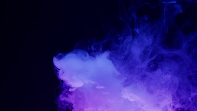 Smoke texture on black background in blue neon light. Smoking, steam clouds of vapour close-up. Burning, fog. 