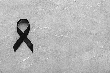 Black funeral ribbon on grey background