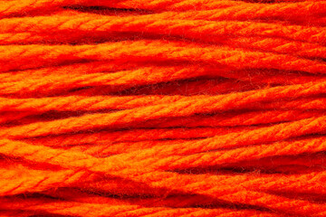 Orange wool yarn for knitting as background, closeup