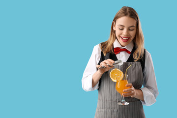 Female bartender with ice cube and cocktail on blue background