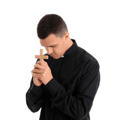 Young priest with cross praying on white background