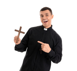 Young priest pointing at cross on white background