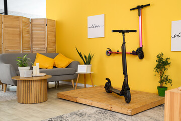 Interior of stylish living room with electric scooters and sofa