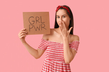 Portrait of young pin-up woman holding sign with text GRL PWR on pink background. Women's History...